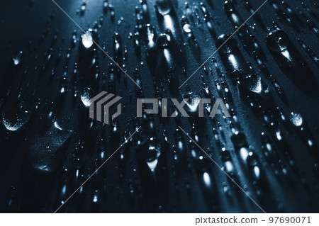 Round drops of water on dark background. Through transparent drops of water pass rays of light. View Round drops of water on dark background. Through transparent drops of water pass rays of light. View 97690071