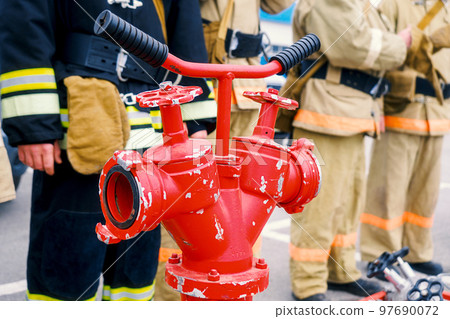 rescuers stand in line in row. Fire brigade against background of red fire crane. Background for rescuers stand in line in row. Fire brigade against background of red fire crane. Background for 97690072