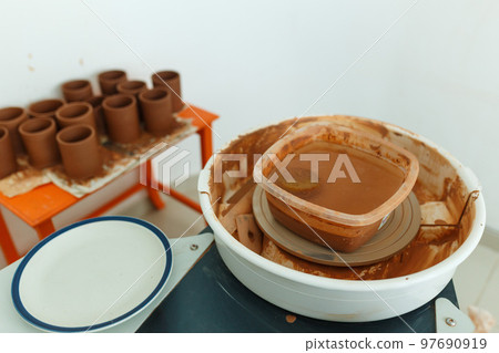 Handicraft ceramic pottery studio. Cups made on pottery wheel. Small business art and craft product concept Handicraft ceramic pottery studio. Cups made on pottery wheel. Small business art and craft product concept 97690919