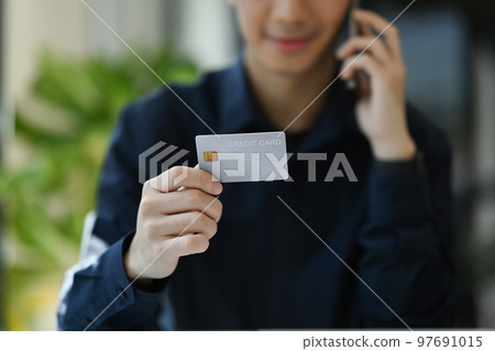 Cropped image of man hand holding a credit card for financial transactions. Finance, loan, savings concept Cropped image of man hand holding a credit card for financial transactions. Finance, loan, savings concept 97691015