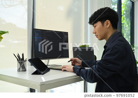 Asian man developer working with coded data on computer screen. Developing programming and coding technologies concept 97691052