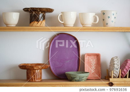 Handmade craft glazed modern ceramics shop. Eco friendly sustainable tableware wabi sabi style shopping on local market. Side view Handmade craft glazed modern ceramics shop. Eco friendly sustainable tableware wabi sabi style shopping on local market. Side view 97691636
