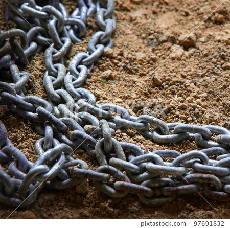 An old metal chain lies on the ground An old metal chain lies on the ground 97691832