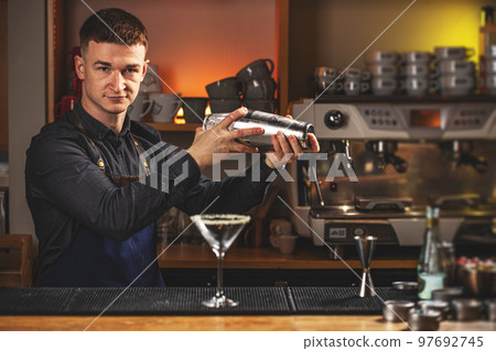 Professional bartender mixing a cocktail Professional bartender mixing a cocktail 97692745