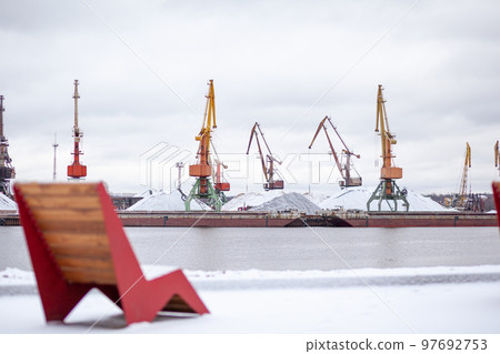 River port in winter. Port cranes on the bank of the river. River port in winter. Port cranes on the bank of the river. 97692753