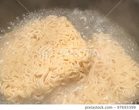 Boil dried ramen noodles in a pot 97693399