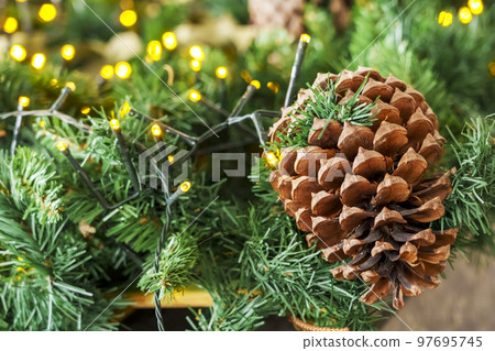 Christmas decorations with a fir branch and a cone with bright lights Christmas decorations with a fir branch and a cone with bright lights 97695745