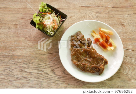 grilled beef steak dressing gravy sauce with French fries dressing ketchup on plate and salad grilled beef steak dressing gravy sauce with French fries dressing ketchup on plate and salad 97696292