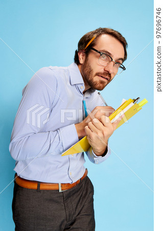 Scared mature man, businessman in office dress code making notes at notebook over blue background. Human emotions, work, mental health 97696746