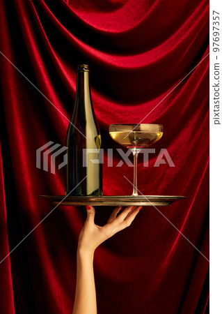 Traditional luxury taste. Bottle and glass with champagne over dark red silk background. Valentine's Day celebration Traditional luxury taste. Bottle and glass with champagne over dark red silk background. Valentine's Day celebration 97697357