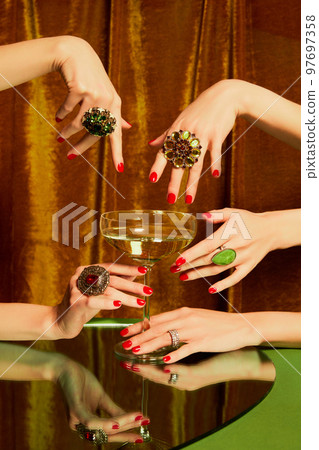Female hands around glass with champagne over golden background. Luxury, festive aesthetics. Christmas party Female hands around glass with champagne over golden background. Luxury, festive aesthetics. Christmas party 97697358