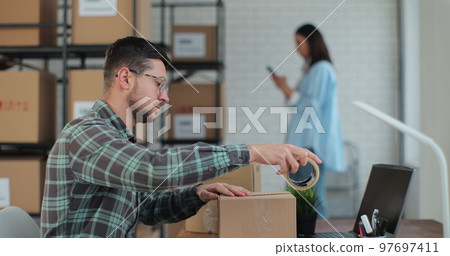 A business owner works in a warehouse with employees. The man manager is patskiing and the yellow jumper is sold, so I am an online customer. 97697411