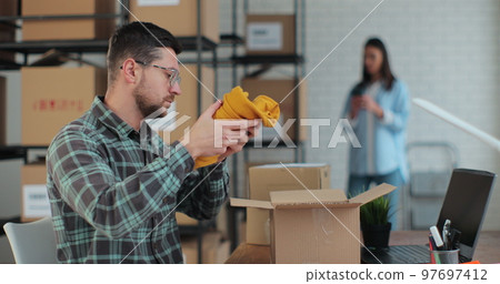 A business owner works in a warehouse with employees. The man manager is patskiing and the yellow jumper is sold, so I am an online customer. 97697412