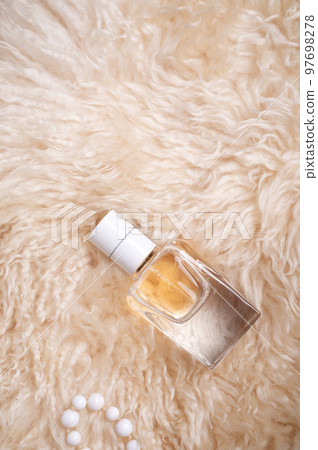 fragrance bottle at sheepskin fur. glamour concept. flat lay fragrance bottle at sheepskin fur. glamour concept. flat lay 97698278