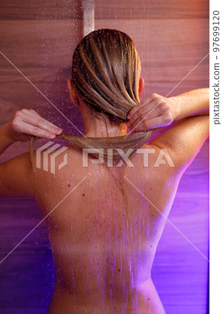 Beautiful woman washes her hair in the shower 97699120