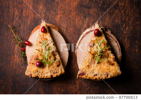 Two pieces of grated cranberry pie on wooden plates Two pieces of grated cranberry pie on wooden plates 97700813