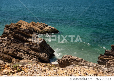 Beautiful landscape of the Penedo da Saudade Lighthouse in Sao Pedro de Moel, Portugal with the cliffs and ocean waves in the foreground 97700843