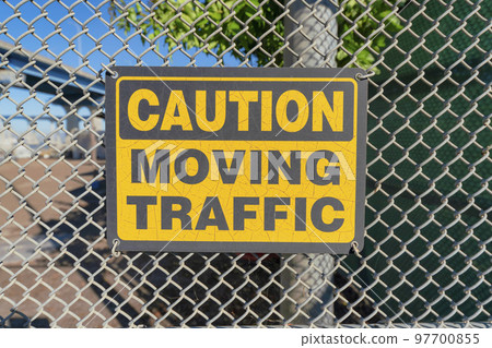 Caution moving traffic sign on a mesh fence at Coronado, San Diego, California 97700855