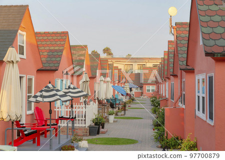 Rows of small houses with coral palette and plants on the bricks path Rows of small houses with coral palette and plants on the bricks path 97700879