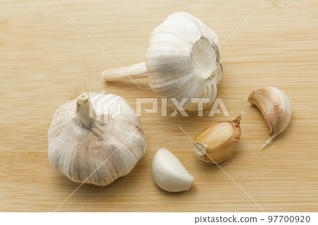 garlic cloves and garlic bulb on wooden background, healthy food, copy space. Banner, cover, mockup 97700920