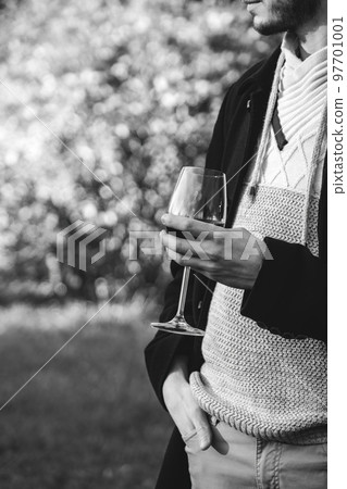 Stylish man poses with glass of alcohol drink outdoors Stylish man poses with glass of alcohol drink outdoors 97701001