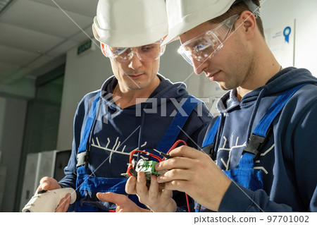 Technicians check motherboard for plug to charge EV Technicians check motherboard for plug to charge EV 97701002