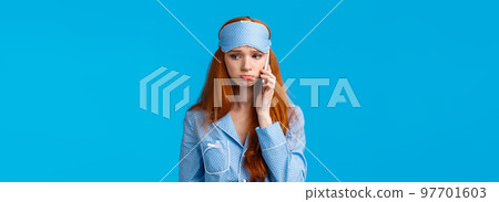 Sulky and gloomy upset cute silly redhead girl calling girlfriend talking about problems, had bad dream, holding smartphone near ear, having phone call in nightwear and sleep mask 97701603