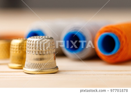 Threads and sewing accessories on wooden table 97701878