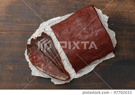 Sliced basturma meat on brow wooden background 97702033