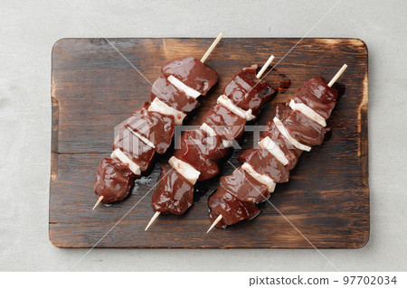 Raw beef liver on skewers on board Raw beef liver on skewers on board 97702034