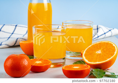 Bottle of orange juice and fresh oranges on table 97702180