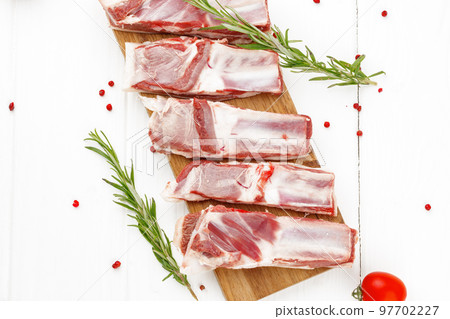 Raw meat ribs on wooden board on white background Raw meat ribs on wooden board on white background 97702227