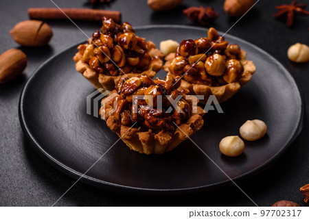 Sweet tasty tart with nuts and honey on a dark concrete background 97702317