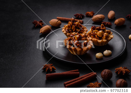 Sweet tasty tart with nuts and honey on a dark concrete background 97702318