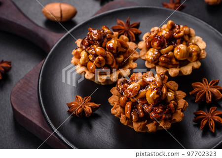Sweet tasty tart with nuts and honey on a dark concrete background Sweet tasty tart with nuts and honey on a dark concrete background 97702323