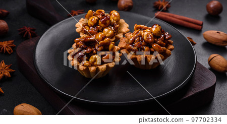 Sweet tasty tart with nuts and honey on a dark concrete background Sweet tasty tart with nuts and honey on a dark concrete background 97702334