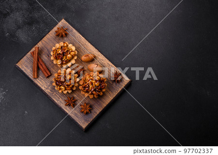 Sweet tasty tart with nuts and honey on a dark concrete background Sweet tasty tart with nuts and honey on a dark concrete background 97702337