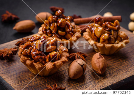 Sweet tasty tart with nuts and honey on a dark concrete background 97702345