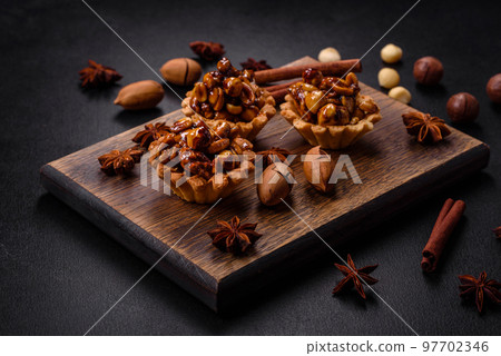 Sweet tasty tart with nuts and honey on a dark concrete background 97702346