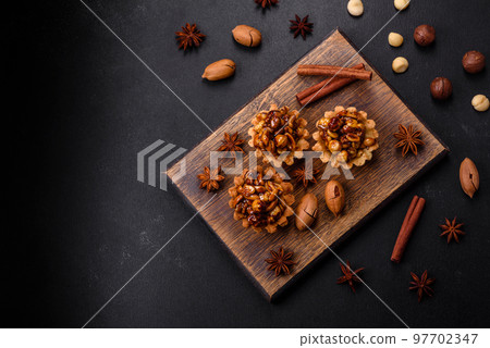 Sweet tasty tart with nuts and honey on a dark concrete background 97702347