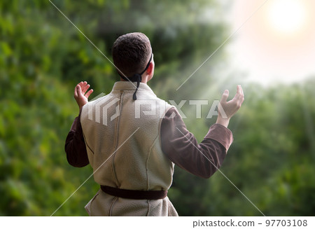 Praying man with raised hands 97703108