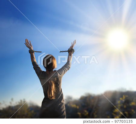 Tied hands raised to the sky 97703135
