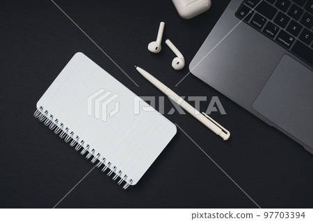 Empty white notepad with copy space, pen, laptop are on the table, top view. 97703394