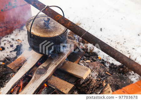 Boiling cauldron with tourist soup hangs over an open fire Boiling cauldron with tourist soup hangs over an open fire 97703678