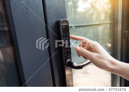 Female hand pushing the key of the free smart lock. 97703878