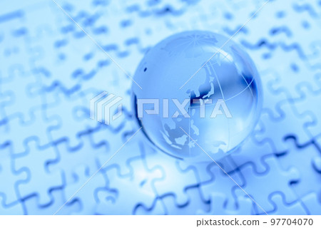 Blue globe on top of a disjointed jigsaw puzzle Blue globe on top of a disjointed jigsaw puzzle 97704070