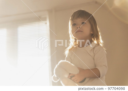charming blonde baby with a toy in the morning 97704098