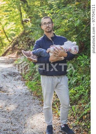 Father holding a sleeping baby in the park Father holding a sleeping baby in the park 97704111