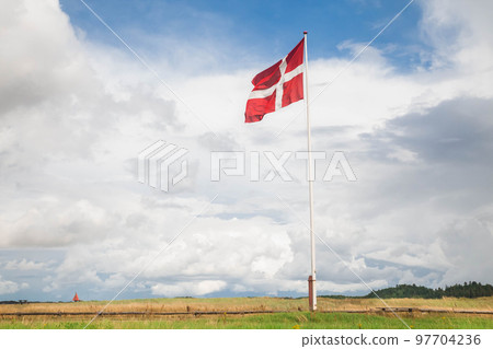 Danish flag on a flagpole against a beautiful cloudy sky Danish flag on a flagpole against a beautiful cloudy sky 97704236
