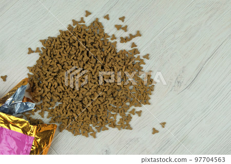Dry fodder for cats and dogs in package on a wooden background. Top view. Copy space. Dry fodder for cats and dogs in package on a wooden background. Top view. Copy space. 97704563